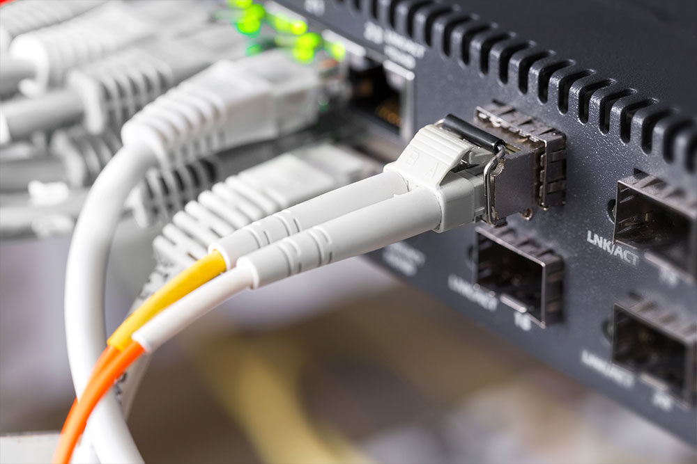 Close-up of high-speed fibre channel network switch and patch cables in data center.